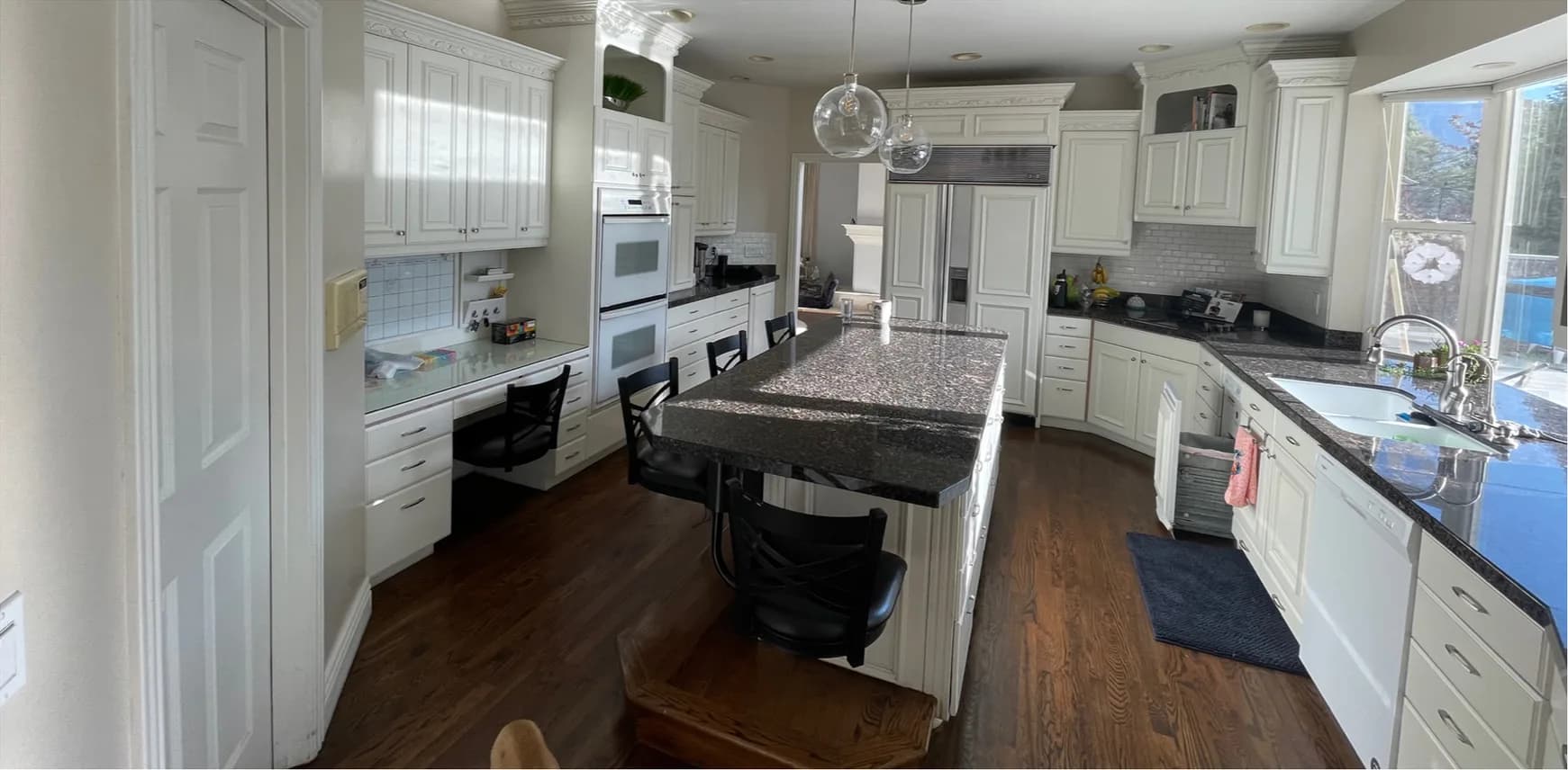 Before — kitchen remodel in Utah, from a traditional white kitchen with dark granite to a modern white kitchen with a waterfall quartz island